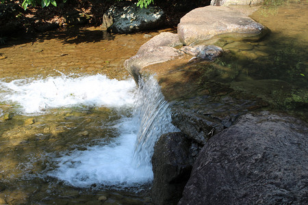 岩石上水流下激起水花自然风景摄影图