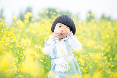 正在油菜花海里玩耍小女孩摄影图