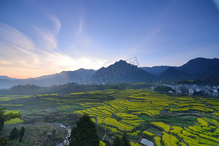 春天日出油菜花田山脉天空自然风景摄影图