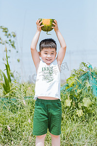 盛夏西瓜节摄影照片_夏天抱着西瓜的小男孩