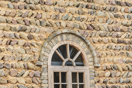 复古墙面摄影照片_鹅卵石铺建的房屋窗子摄影图
