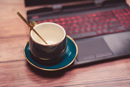 笔记本呢电脑上的咖啡杯摄影图