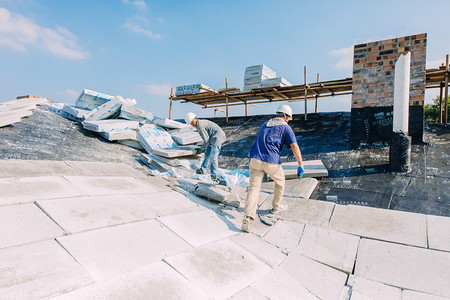 屋顶上施工的建筑工人摄影图