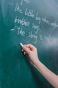 教师节黑板写字摄影照片_教师在黑板上用粉笔写字摄影图