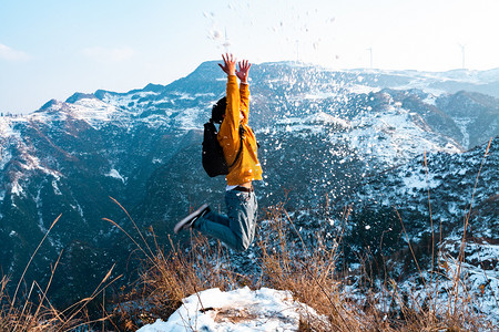 雪山上跳起来人物摄影图