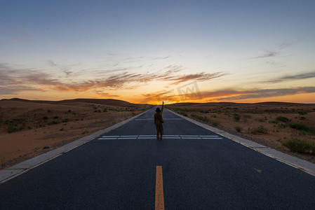 摄影照片_夕阳落日人在公路摄影图