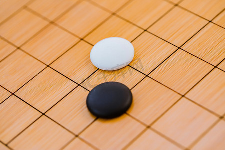 萤火虫黑白摄影照片_围棋棋盘上的两颗黑白棋子