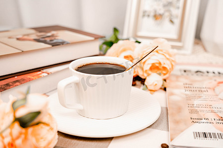 一杯咖啡摄影照片_温馨卧室书桌一杯咖啡摄影图