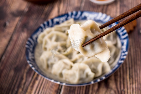 美食筷子夹起的水饺摄影图