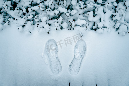 冬日户外雪景下的一双脚印