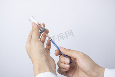 护士拿针管吸取疫苗特写图