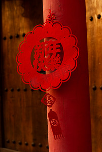 传统中国年味夕阳新年快乐花环在红色柱子上挂着摄影图配图