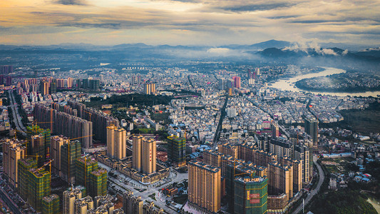 智慧监管暖色调摄影照片_城市夕阳城市日落城市用无人机航拍摄影图配图