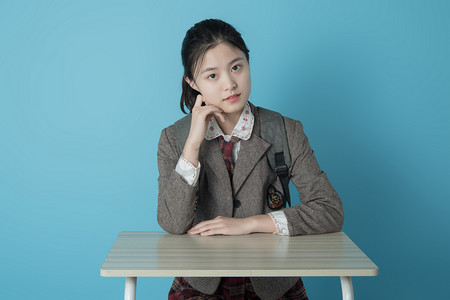 学生人像白天穿韩式校服的女学生室内手托脸颊摄影图配图