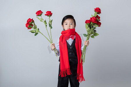 新年新春拜年穿西装的男孩室内拿着玫瑰花摄影图配图