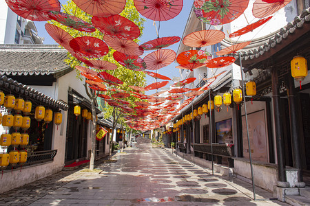 古镇街道户外倒挂的油纸伞摄影图配图