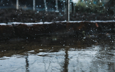 飞溅摄影照片_雨水下雨水滴地面飞溅摄影图配图