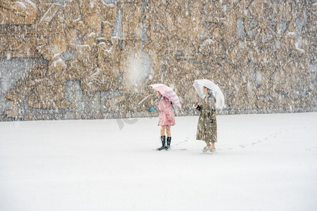 下雪天白天雪地上的女孩广场玩耍摄影图配图