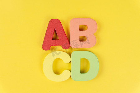 黄色背景ABCD大写英文字母拼写组合摄影图配图