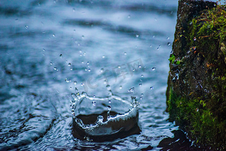 水浪水珠摄影照片_下雨天水面水滴雨水节气雨滴水面水花飞溅摄影图配图