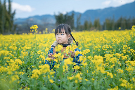 田野乡村人物摄影照片_农村春天暖春女孩赏花油菜花地赏花摄影图配图