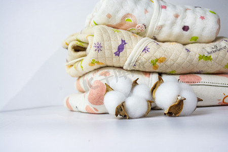 新疆棉花摄影照片_婴儿安心棉服下午棉衣服棉花球室内静物摄影图配图