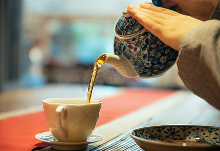 茶文化展板摄影照片_倒茶下午茶壶茶桌品春摄影图配图