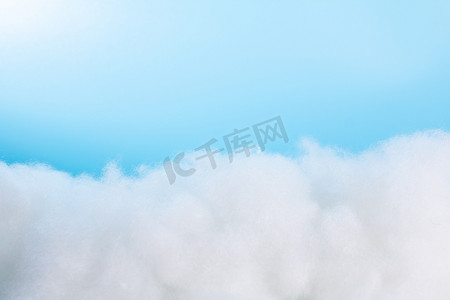 棉花棚拍蓝色背景前的棉花云室内静物摄影图配图