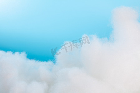 棉花室内蓝色背景前的棉花云棚拍静物摄影图配图
