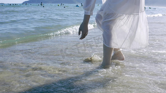 海边美女背影走在沙滩上