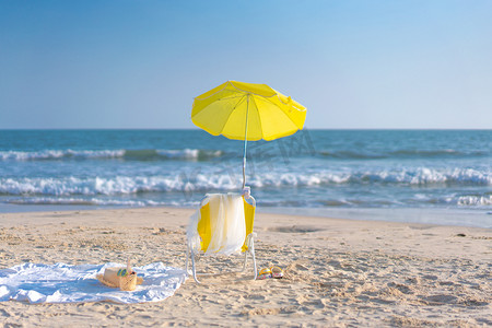 平静的海面摄影照片_度假中的沙滩椅下午儿童沙滩椅沙滩度假摄影图配图