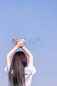 日韩少女街拍摄影照片_人物清晨日系jk制服女孩蓝天下举手摄影图配图