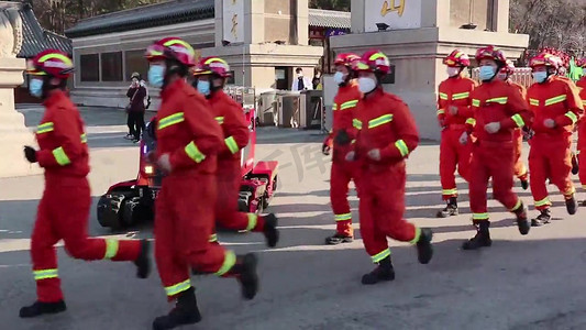 消防班会摄影照片_全地形消防机器人和整齐的消防员队伍走过