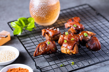 餐饮美食白天放在烧烤架上的烤猪蹄桌面暗调摆拍摄影图配图