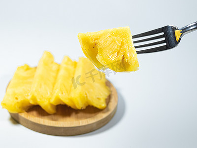 一盘菠萝凤梨白天菠萝凤梨餐厅叉子吃菠萝摄影图配图