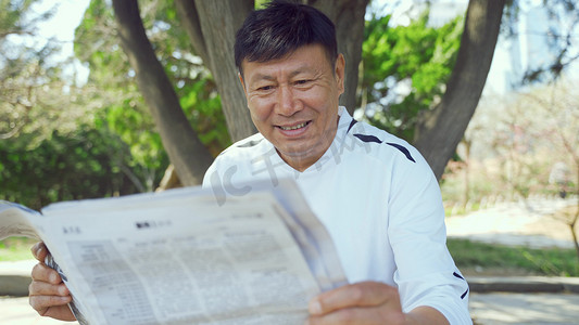 春天公园长椅老年人看报纸悠闲退休生活人像
