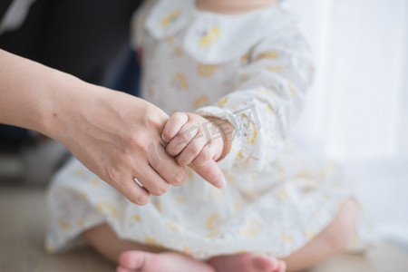 母亲节白天母亲和小宝宝室内握手摄影图配图