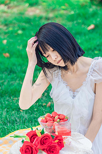野餐夏季早上美女户外吃草莓摄影图配图