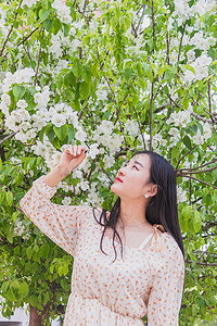 海棠花人像早上美女户外公园闻花香摄影图配图