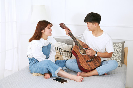 情侣情人节男朋友给女朋友弹吉他摄影图配图