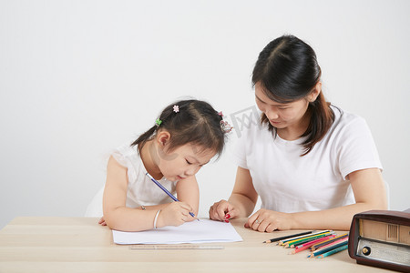 幼儿园家长会摄影照片_儿童节儿童节母女一起写字摄影图配图