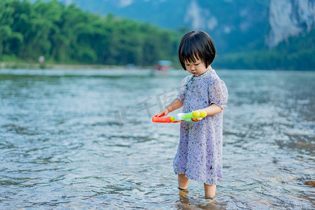 夏天玩水摄影照片_阳朔河边女孩夕阳女孩阳朔玩水摄影图配图