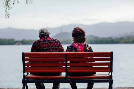 爱情摄影照片_老年人的爱情夕阳红傍晚老夫老妻公园长椅坐在长椅上摄影图配图
