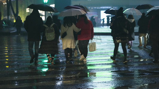 夜晚雨中打伞行走的行人实拍