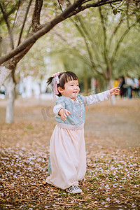 小孩奔跑摄影照片_汉服儿童白天小女孩户外公园伸手奔跑摄影图配图
