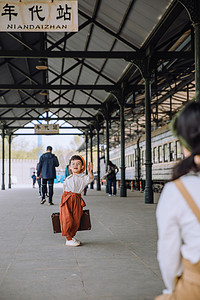 文艺儿童白天拎着行李箱的小男孩火车站台挥手再见摄影图配图