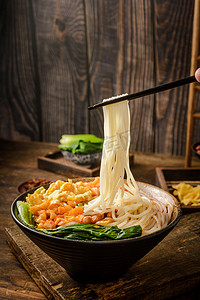 美食白天螺蛳粉木桌上筷子夹起摄影图配图