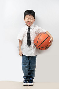六一儿童节白天男孩室内抱篮球摄影图配图