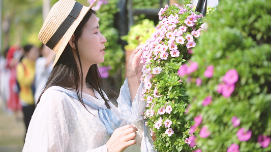 花开之季摄影照片_晴天下美丽女子在花丛中欣赏风景