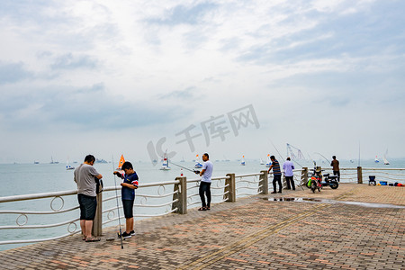 休闲娱乐白天岸上钓鱼的人们户外海边钓鱼摄影图配图